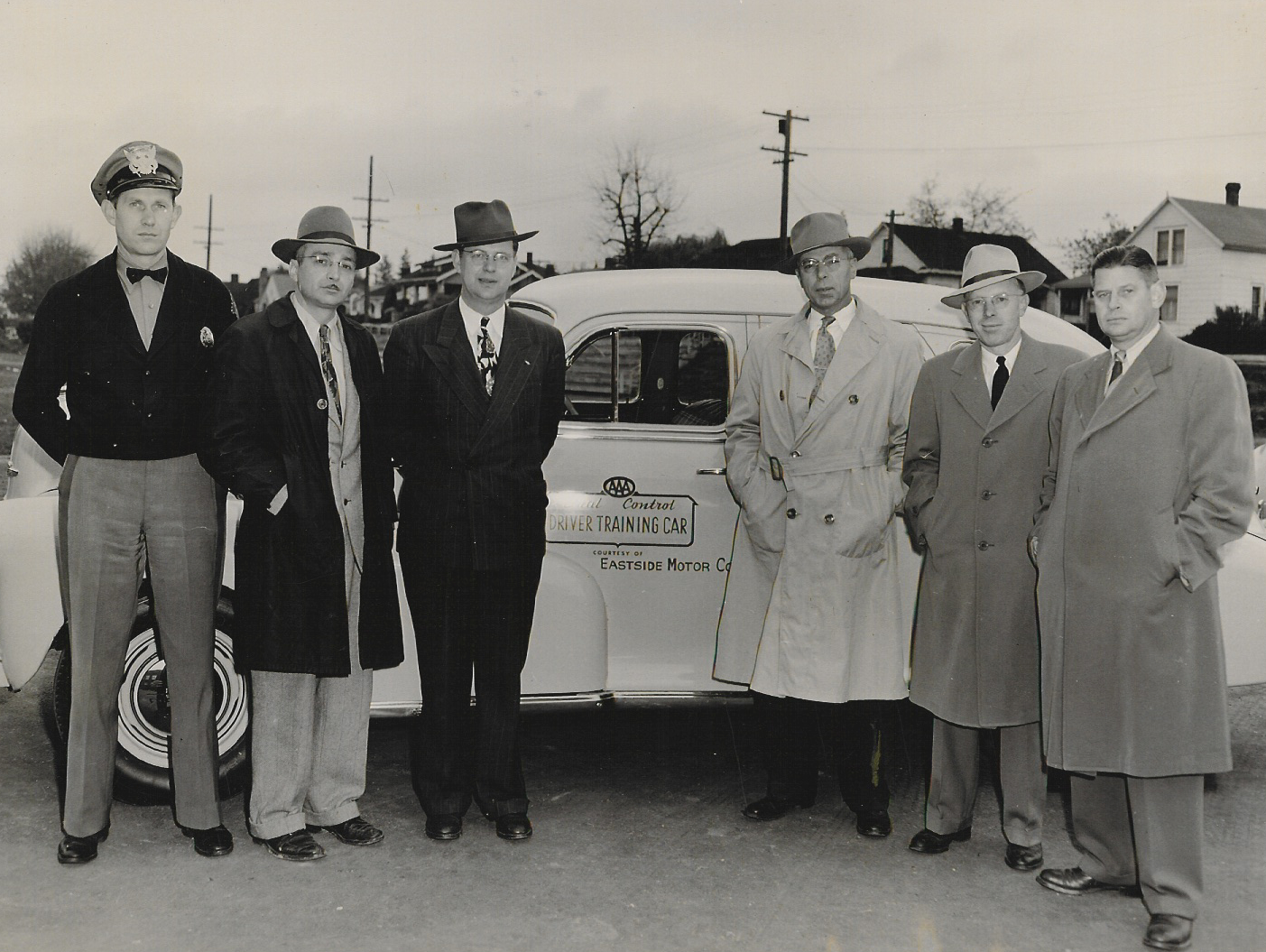 Vintage photo of people infront of a car